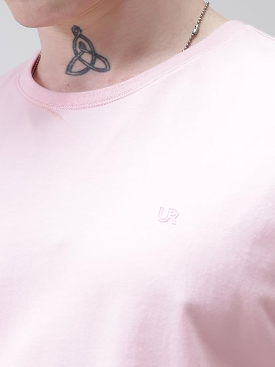 Person wearing a pink sweatshirt with a visible brand logo, showing a tattoo on the neck.