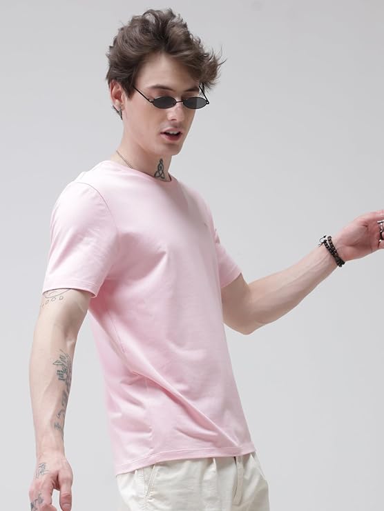 Person wearing a pink t-shirt and sunglasses on a plain background