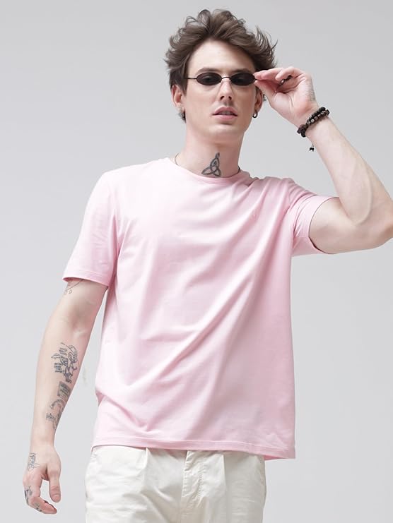 Person wearing a pink t-shirt and sunglasses on a plain background