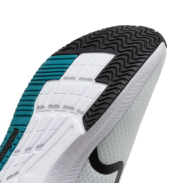 Close-up of a sports shoe with white, black, and teal sole on a white background