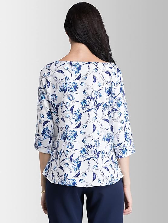 Woman wearing a blue and white floral blouse against a gray background