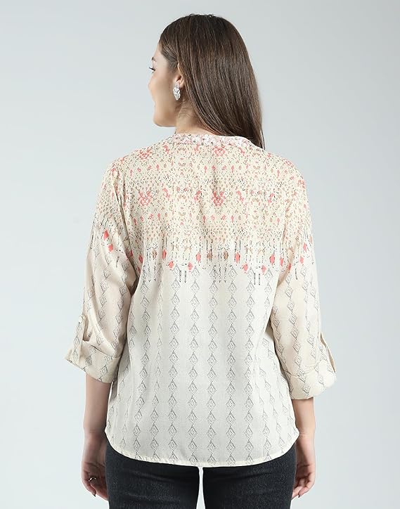 Woman wearing a beige floral blouse with a plain background